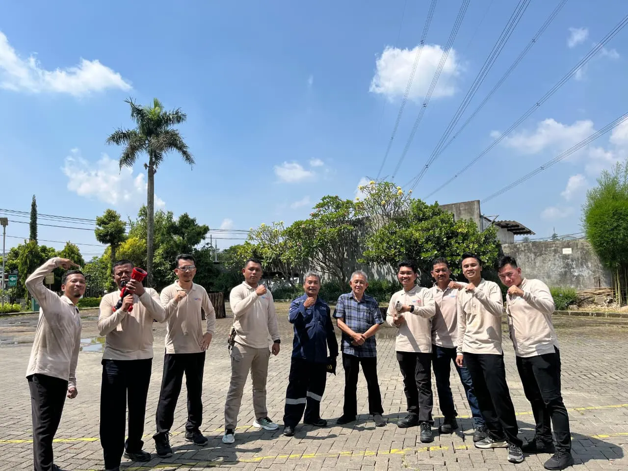 Foto bersama tim instruktur pelatihan pemadam kebakaran di area latihan luar ruangan
