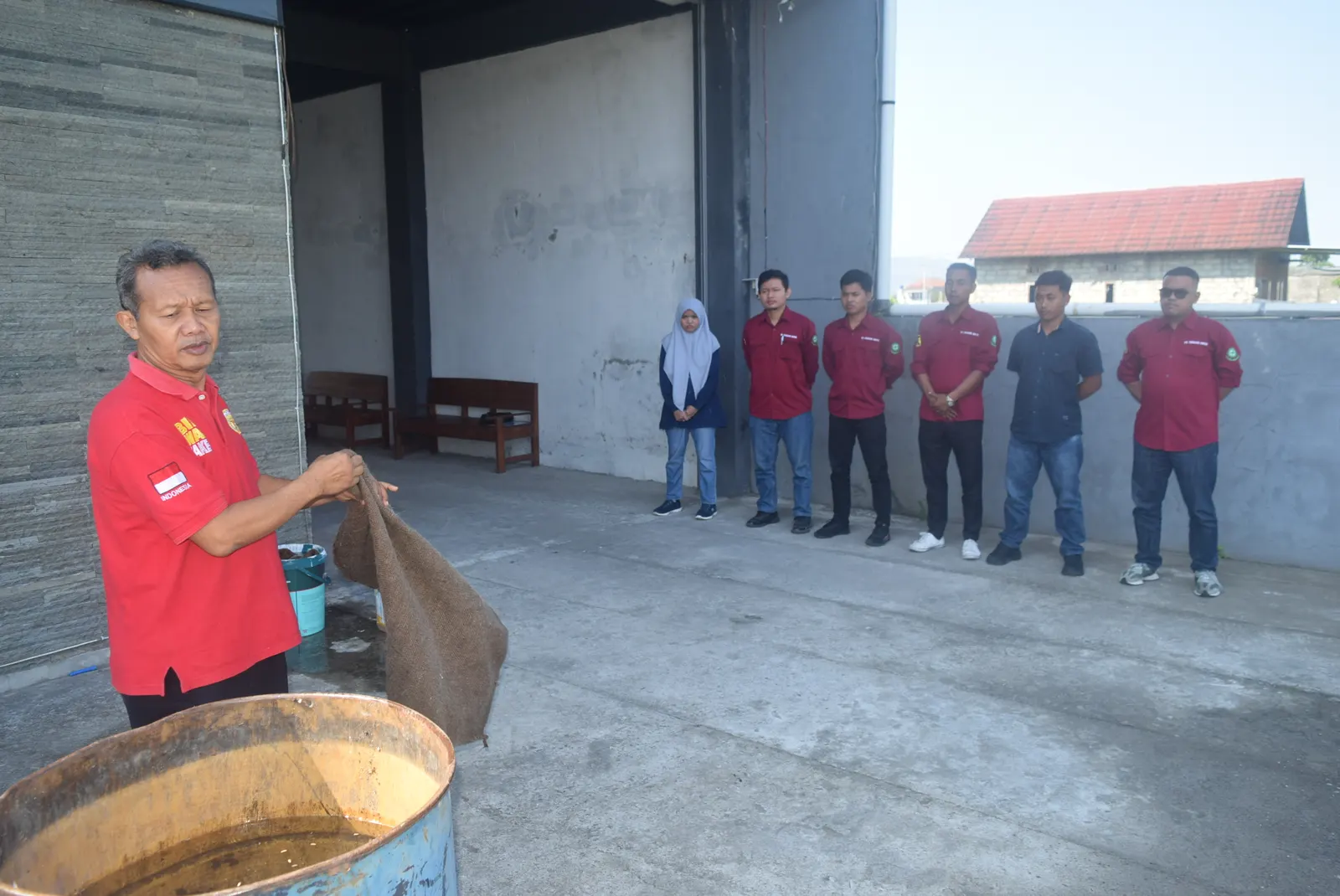 Instruktur mendemonstrasikan penggunaan karung basah untuk pemadaman api kepada peserta berseragam merah