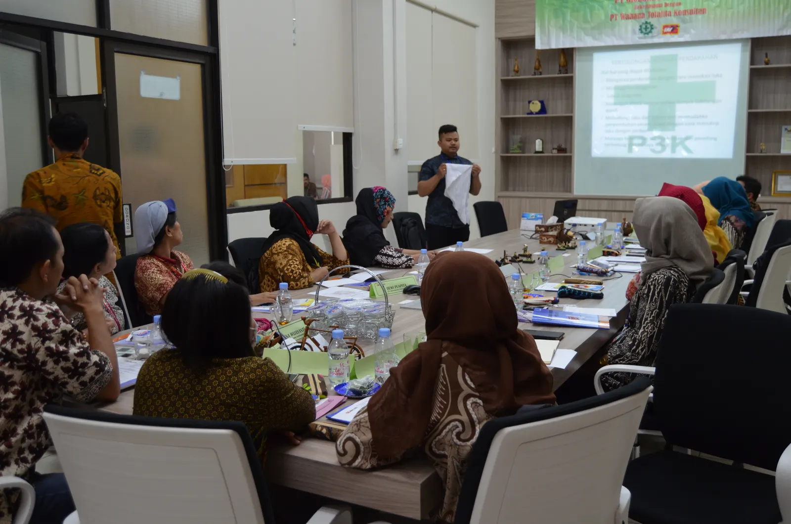 Instruktur menyampaikan materi P3K kepada peserta di ruang rapat perusahaan