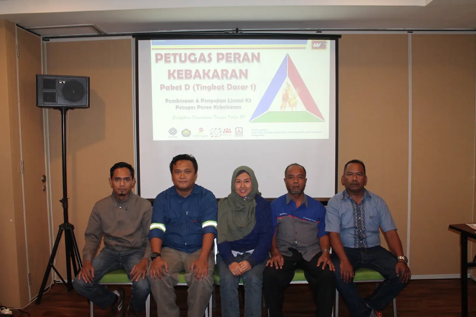 Peserta pelatihan Petugas Peran Kebakaran Paket D Tingkat Dasar 1 berfoto di depan layar presentasi di ruang kelas