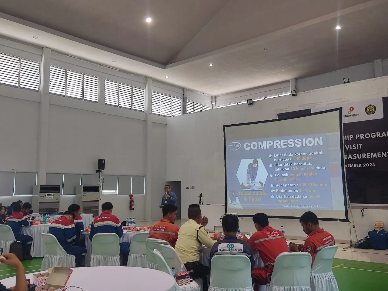 Pelatihan P3K teknik kompresi dada CPR oleh instruktur kepada peserta Pertamina Fire Brigade dengan slide presentasi SKK Migas